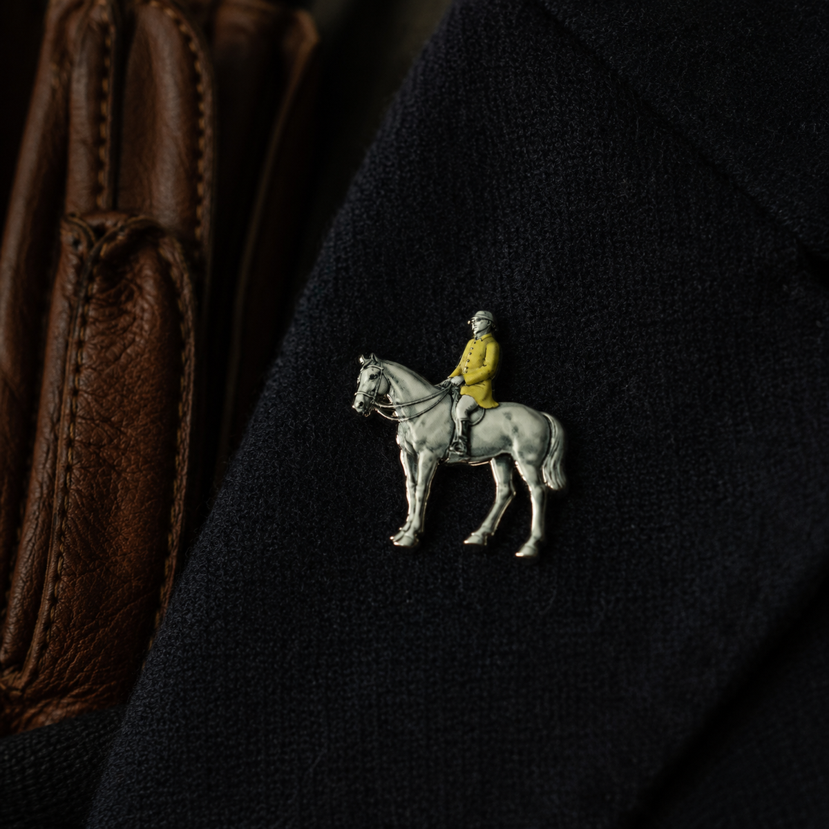 Pin George – Fuchsjäger hoch zu Ross am Revers eines dunkelblauen Mantels