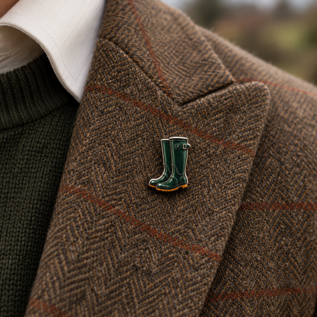 Pin Wellis: Gummistiefel-Pin am Revers eines braunen Tweed-Sakkos